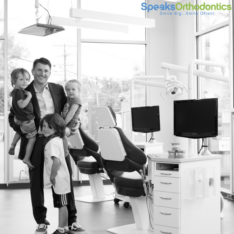 Adult man with three children at orthodontist