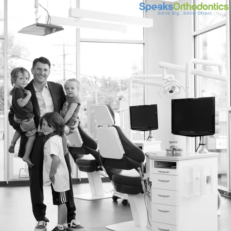 Adult man with three children at orthodontist