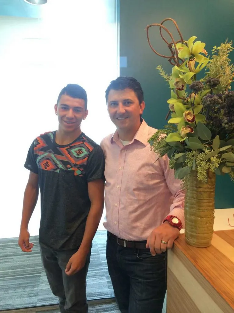 Dr. Speaks smiling with a teen at a community event