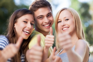 Three teens thumbs up after wearing braces