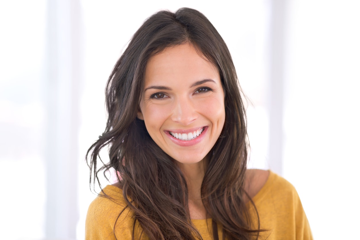 Young adult brunette smiling at camera