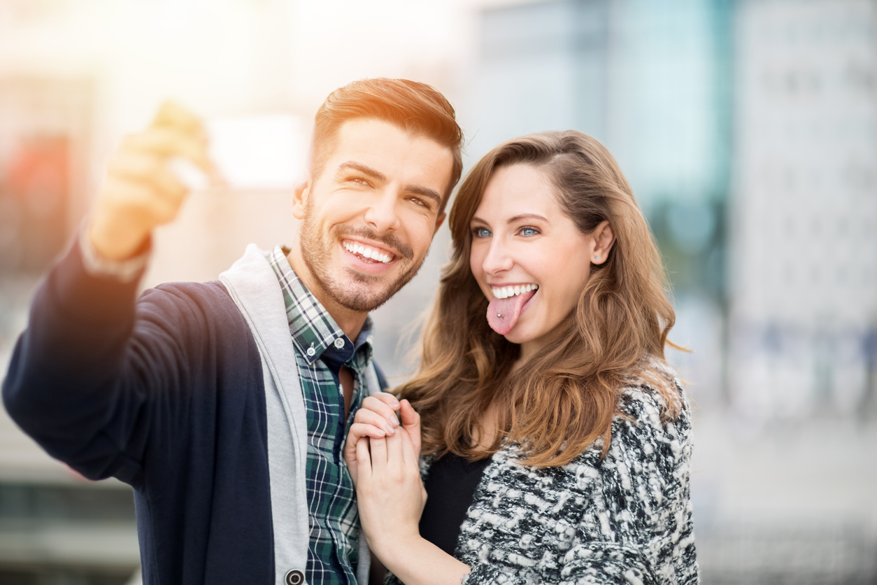 Adult man and woman smiling while taking selfie