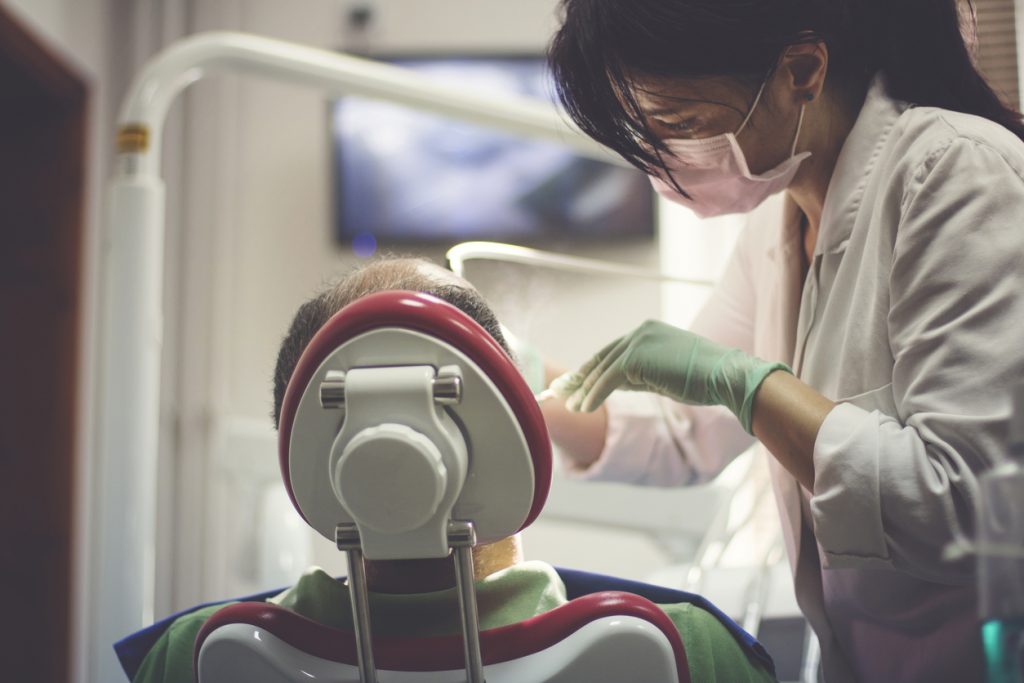 Dentist performing exam patient back of head
