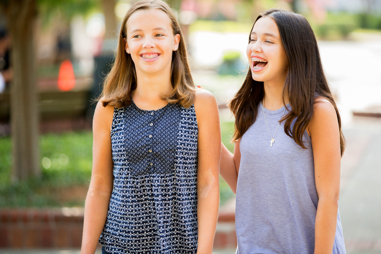 Two young girls with braces laughing