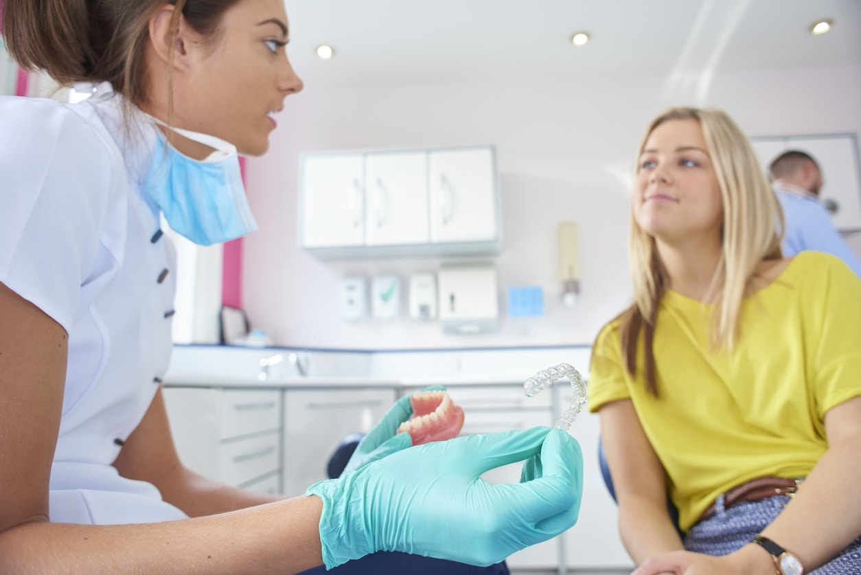 Dental assistant explaining Invisalign to teen girl