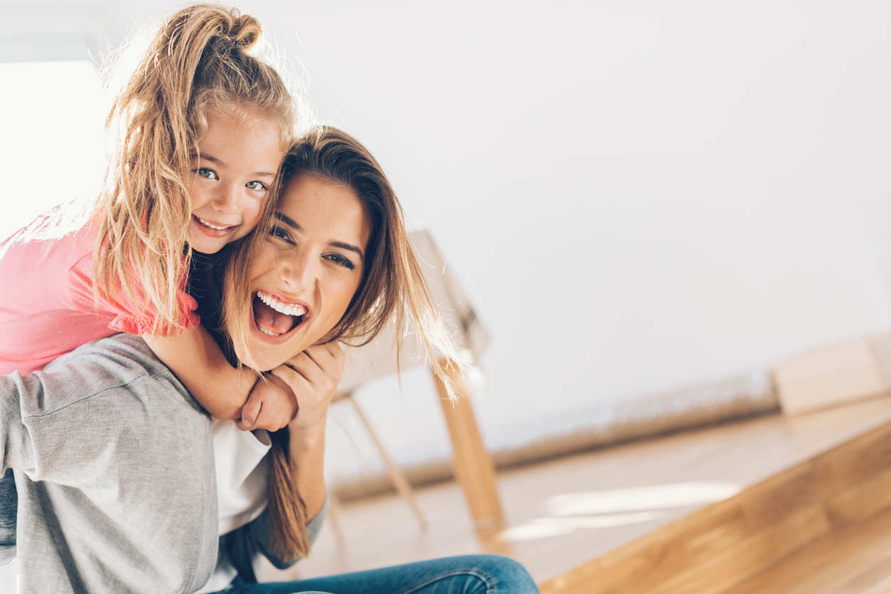 Young girl hugging mother and smiling