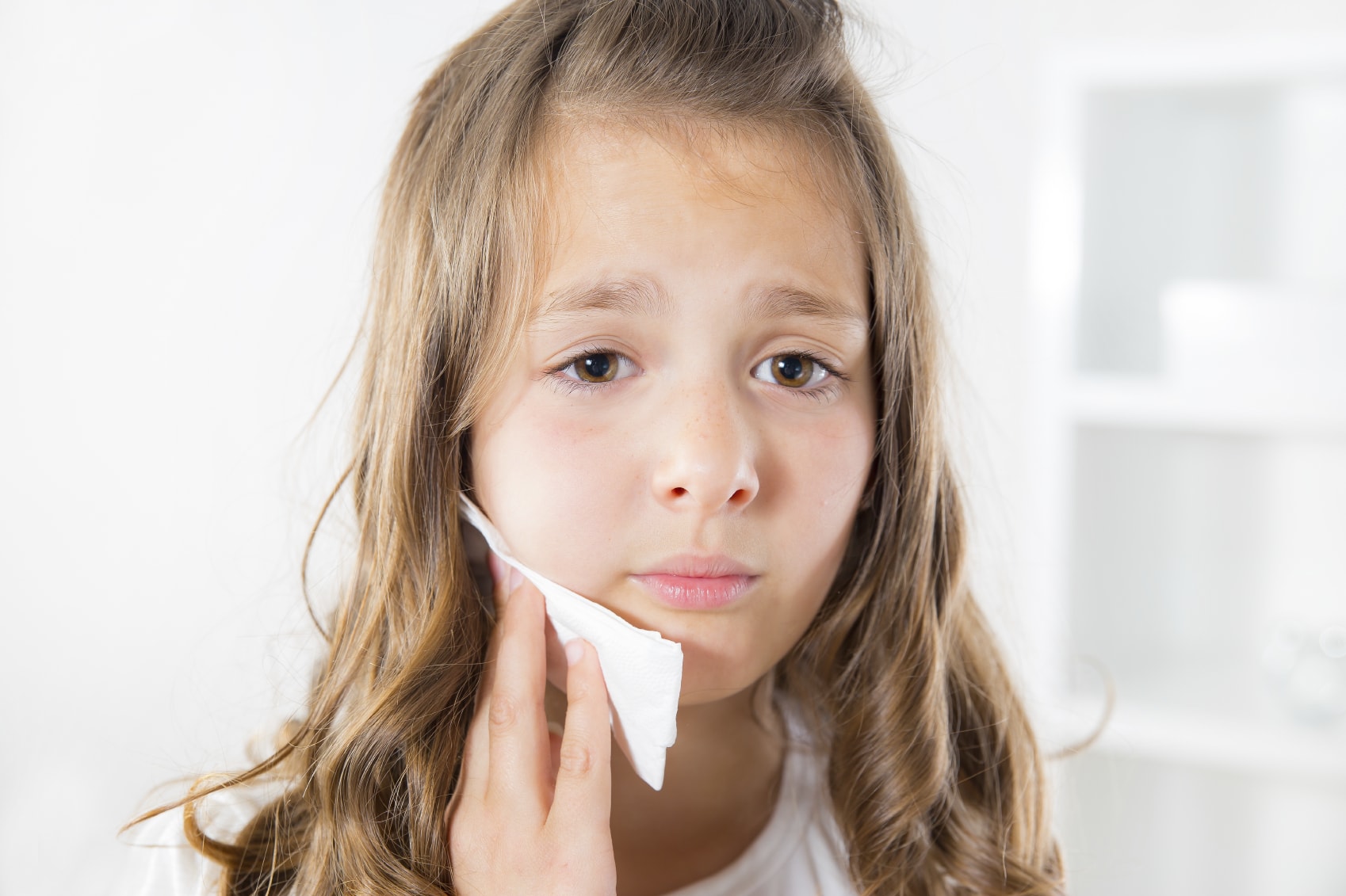 Girl holding ice pack to jaw