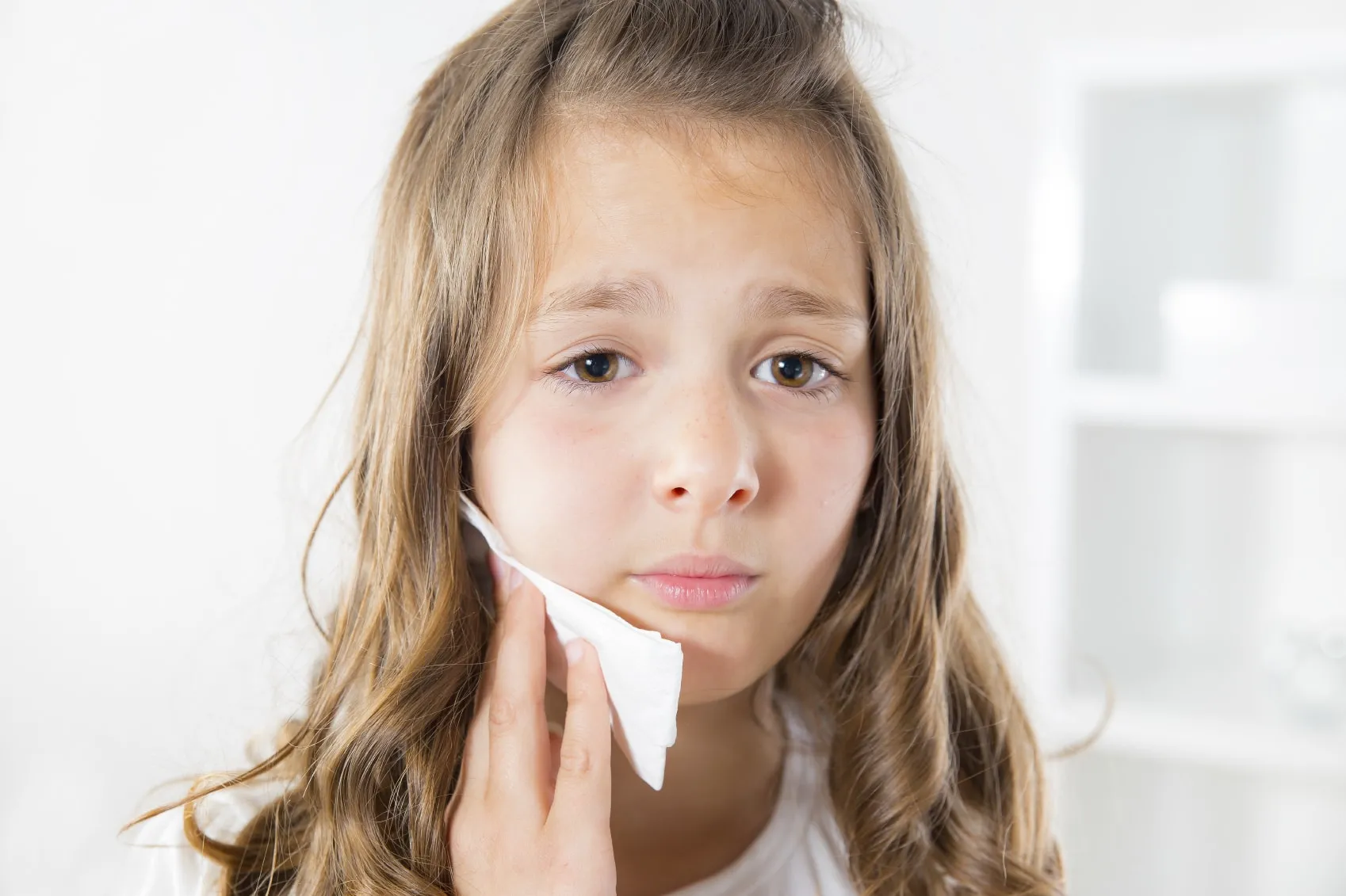 Girl holding ice pack to jaw